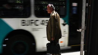 Un hombre espera por el transporte público al salir de trabajar, en Santiago.