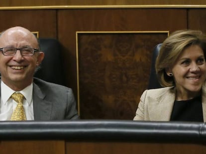 El ministro de Hacienda, Cristóbal Montoro, junto a la ministra de Defensa, María Dolores de Cospedal, tras equivocarse en la votación de una iniciativa sobre el futuro de las autopistas de peaje.