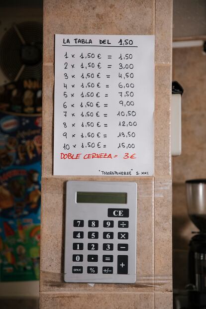 Detalle de los precios de los botellines de cerveza. La decoración del local es clásica, con mobiliario principalmente de madera y paredes repletas de azulejos de color beis.