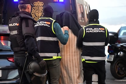 Los agentes de la Policía Nacional conducen a otro de los arrestados en una operación contra el terrorismo yihadista en Ceuta, este viernes.