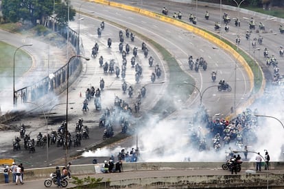 Miembros de las fuerzas de seguridad dispersan a los manifestantes durante una protestas cerca de una base aérea de Caracas, el 24 de junio de 2017.
