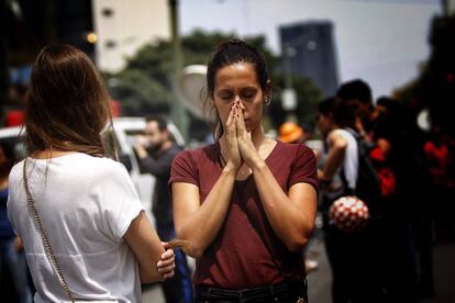 Una mujer reza mientras espera que una persona sea rescatada.