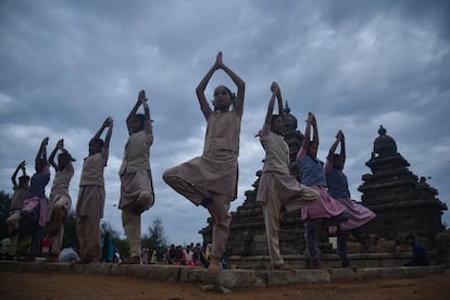 Un grupo de alumnos participa en una sesión de yoga en el Templo de la Orilla, construido entre el 700 y el 728 d. C., a los pies de la bahía de Bengala, en la ciudad india de Mahabalipuram.
