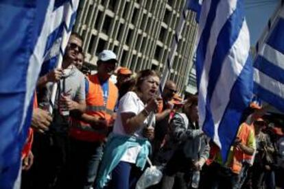 Funcionarios griegos ondean banderas nacionales durante una protesta contra las reformas del Gobierno, en Atenas, Grecia, este viernes.
