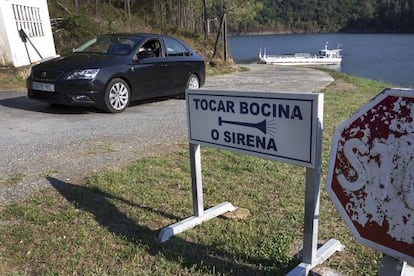 Al fondo, el barco para cruzar el embalse de Portodemouros.