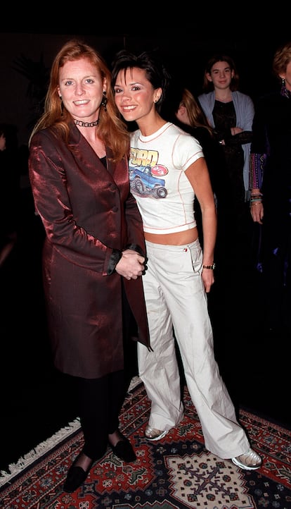 Con Sarah Ferguson y su momento fan. En esta imagen no se puede saber quién era la fan de las dos: si Victoria Beckham, Sarah Ferguson o ambas. Lo que sí se podría adivinar con solo mirar las zapatillas de la posh de las Spice Girls es el año en el que estamos. Las Nike Air Max fueron todo un fenómeno de los mediados y finales de los 90. Unas zapatillas que, aunque vuelven estar en el candelero de la moda, Victoria Beckham no se ha vuelto poner, ni siquiera ahora que por culpa de una lesión se ha visto obligada a ayudarse de muletas confirmando que la Victoria Beckham de entonces está muy alejada, en cuestión de estilo, de la de ahora.
