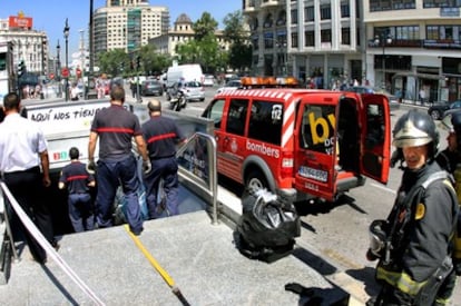 Varios bomberos entran en la estación de Metro en la calle de Xàtiva de Valencia tras el aviso de incendio en una escalera mecánica.