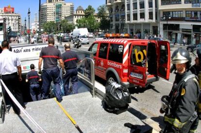 Varios bomberos entran en la estación de Metro en la calle de Xàtiva de Valencia tras el aviso de incendio en una escalera mecánica.