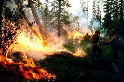 Miembros de los equipos de protección forestal trabajan en la extinción del incendio que devora centenares de miles de kilómetros cuadrados de taiga en Siberia.