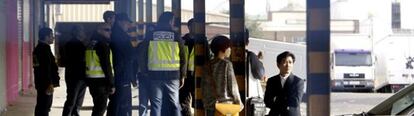 Agentes de la Policía Nacional y ciudadanos chinos durante el registro a negocios en el polígono industrial Cobo Calleja