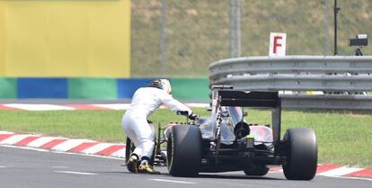 Fernando Alonso empuja su McLaren tras la enésima avería