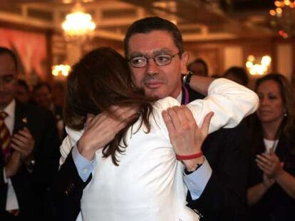 El alcalde Alberto Ruiz-Gallardón abraza a su esposa, Mar Utrera, tras producirse la eliminación de Madrid. A la derecha, la concejal socialista Trinidad Jiménez.