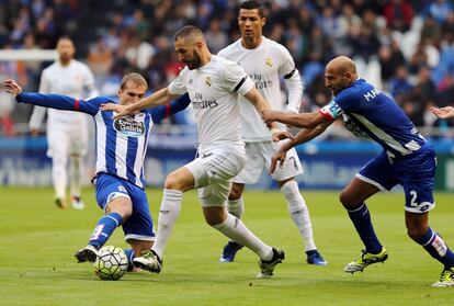 Alex Bergantinos (i) y Manuel Pablo (d) del Deportivo intentan quitar el balón a Benzema.