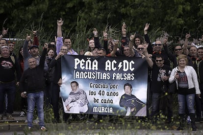 Componentes de la peña murciana Ancustias Falsas muestran una pancarta a la entrada al concierto de AC/DC en Sevilla.