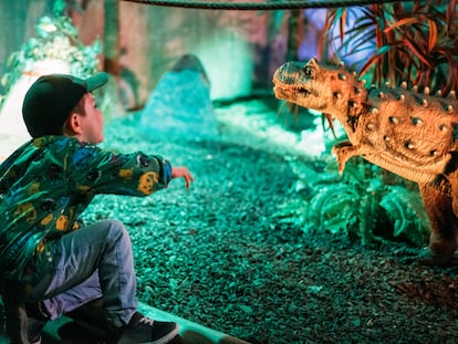 Un niño ruge a un ejemplar de la exposición 'Dinoworld' en Ifema.