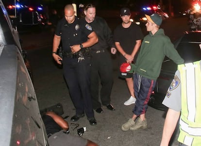 Justin Bieber fala com a polícia enquanto espera a ambulância.