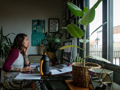 Una mujer realiza teletrabajo en su casa.