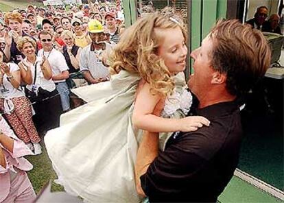 Mickelson abraza a su hija Amanda en la cabina de anotación del hoyo 18.