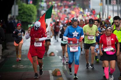 Corredores disfrazados de Capitán América y luchadores, participan en el XXXIX Maratón de la Ciudad de México.