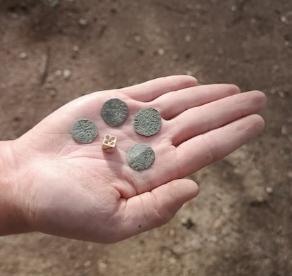 Cuatro de las monedas y un dado hallados en el castillo de Montsoriu.
