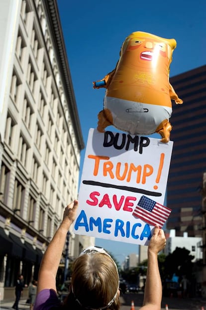 Una manifestante sostiene una imagen en contra del presidente de EE.UU. Donald Trump, durante su visita a San Diego.
