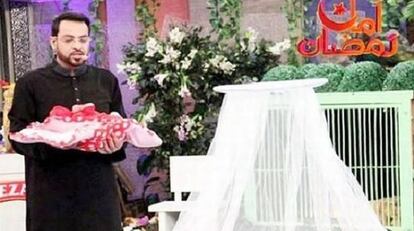El presentador del programa, Aamir Liaquat Hussain, con un bebé en brazos.