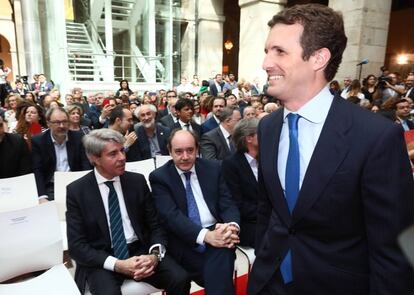 El presidente del Partido Popular, Pablo Casado pasa delante de Ángel Garrido (el primero, sentado), expresidente de la Comunidad de Madrid.
