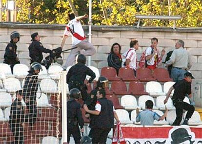 Un policía nacional golpea con una porra a un aficionado del Rayo Vallecano dentro del estadio.