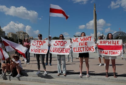 Manifestantes opositores muestran carteles con consignas en contra del Gobierno de Lukashenko, este domingo.