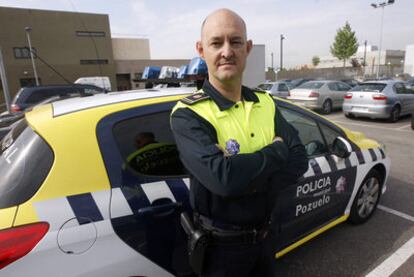 El oficial jefe de la Policía Local de Pozuelo de Alarcón, Francisco Caletrio, delante de un coche patrulla en la sede del cuerpo.