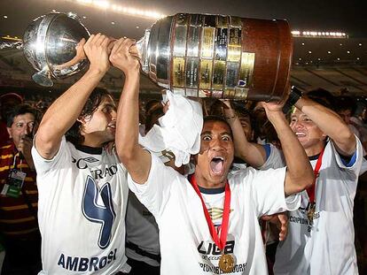 Jugadores de la Liga Deportiva Universitaria de Quito levantan el trofeo de la Copa Libertadores.