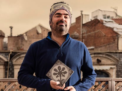 Joan Moliner sostiene en su casa una baldosa del año 1900 de la fábrica Escofet. Es un diseño de Enric Moyà. En la página siguiente, un catálogo de las piezas y la terraza-estudio de Moliner.