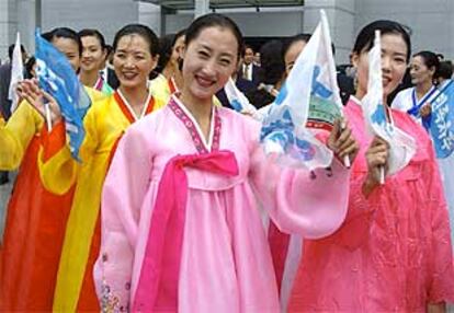 Un grupo de mujeres norcoreanas, con banderas de reunificación, en el aeropuerto de Incheon (Corea del Sur).