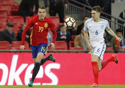 Aspas disputa un balón con el defensa de Inglaterra John Stones.