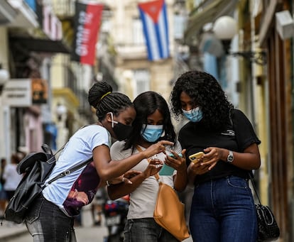 Tres mujeres usan sus teléfonos móviles en La Habana el 14 de julio.