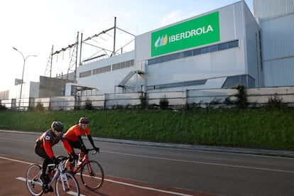 Varios ciclistas pasan junto a unas instalaciones de Iberdrola en Santurce, Bilbao.