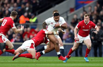 Manu Tuilagi avanza entre varios jugadores de Gales.