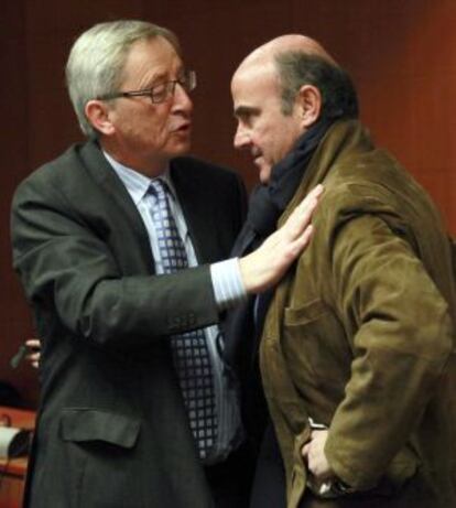 Luis de Guindos conversa con el presidente del Eurogrupo, Jean-Claude Juncker, durante la reunión del Eurogrupo