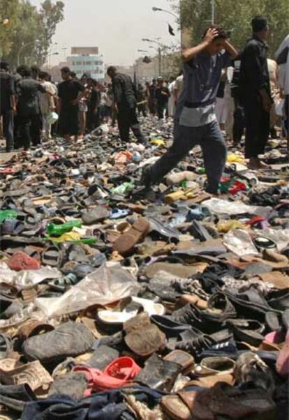 Peregrinos chiíes caminan entre los miles de zapatos abandonados durante la estampida.