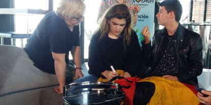 Amaia y Alfred firman en una bandera española con toro.