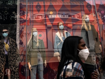 A shopper walks past mannequins donning face masks in Los Angeles, on Dec. 7, 2020.