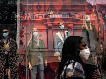 Una mujer camina frente a maniquíes que llevan mascarillas, en Los Angeles, en diciembre de 2020.