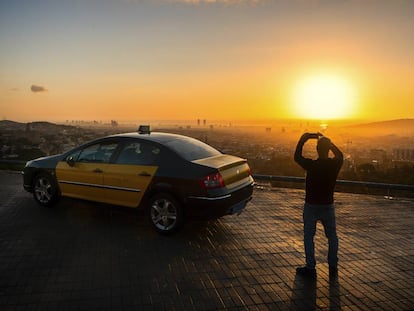 Barcelona. Un taxista de la capital catalana toma fotografías del perfil urbano desde lo alto del monte Tibidabo al amanecer.