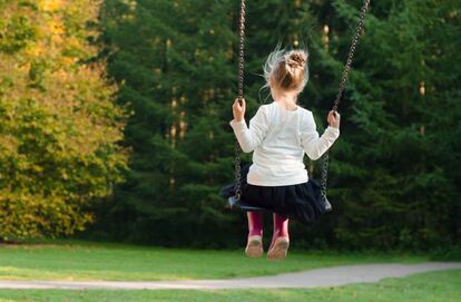 Una niña se columpia en un parque. 