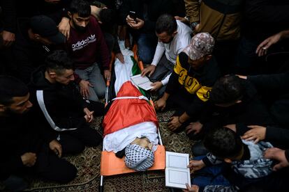 Familiares y allegados rezan alrededor del cuerpo de Mahmoud Abu Haniyeh, de 17 años, durante su funeral en la ciudad de Azzun (Cisjordania). El Ministerio de Salud palestino informó que el joven murió durante los enfrentamientos con el ejército israelí el sábado.