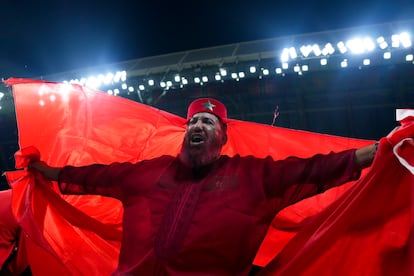 Un aficionado marroquí con una bandera desplegada en las gradas del estadio.