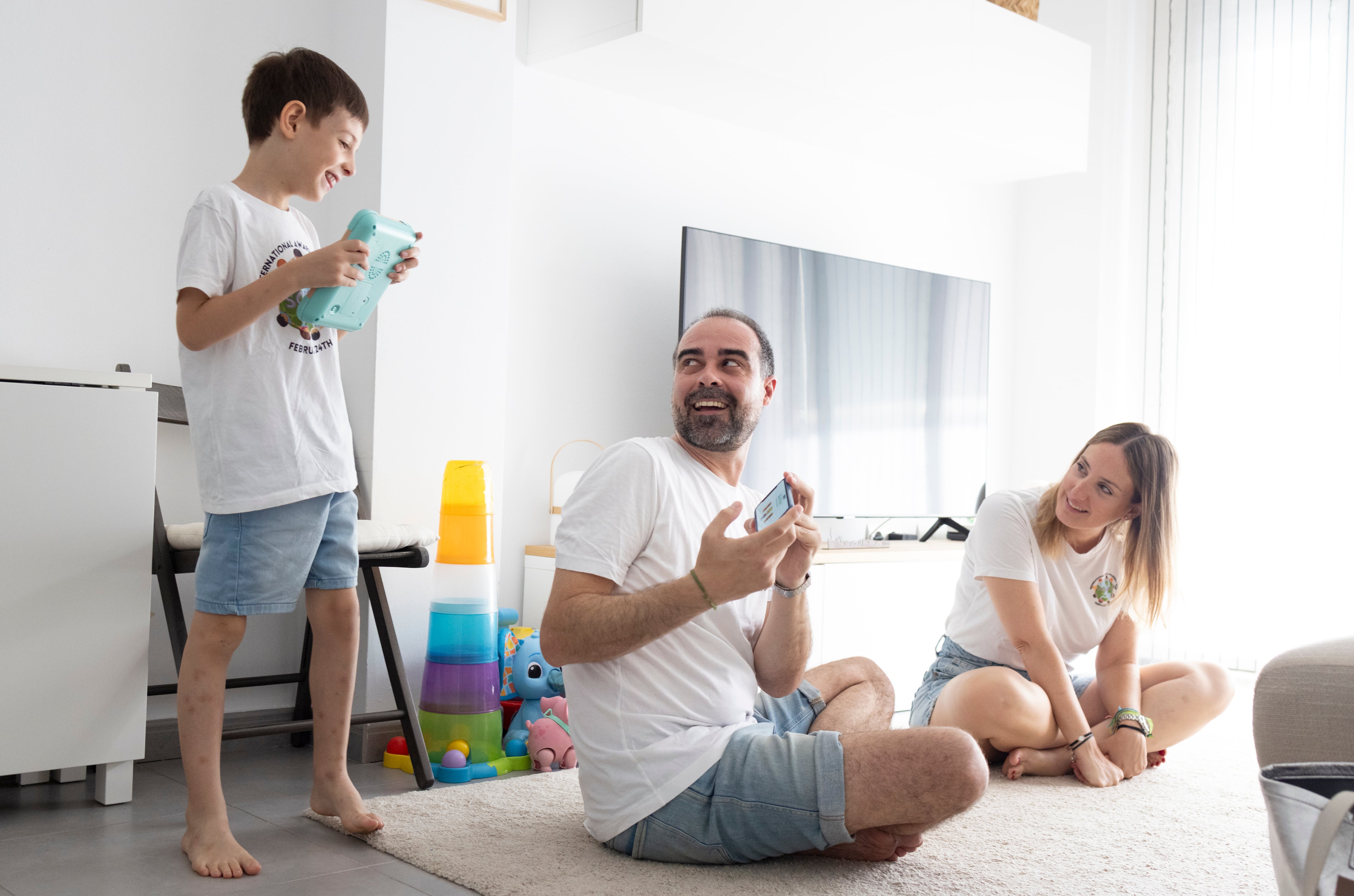 Pau Rotger Pérez-Quintanilla sufre una enfermedad rara que le provoca epilepsia y autismo. En la imagen, juega con sus padres, Fonso y Mar en el salón de su casa, el pasado junio.