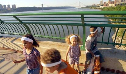 Niños juegan en un puente de Harlem en el río Hudson.