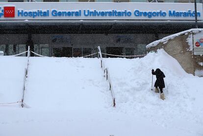 Una mujer intenta acceder al Hospital Gregorio Mara?n, en Madrid, bajo la intensa nevada cada en la capital el 9 de enero.