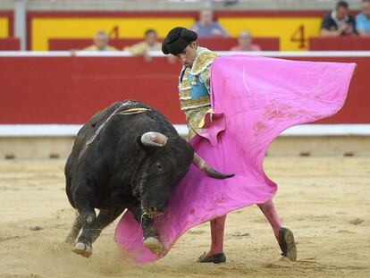 El novillero Rafael Cerro da un pase con el capote al segundo de su lote, durante la primera corrida de los Sanfermines